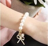 Pulseira de pérolas e laço
